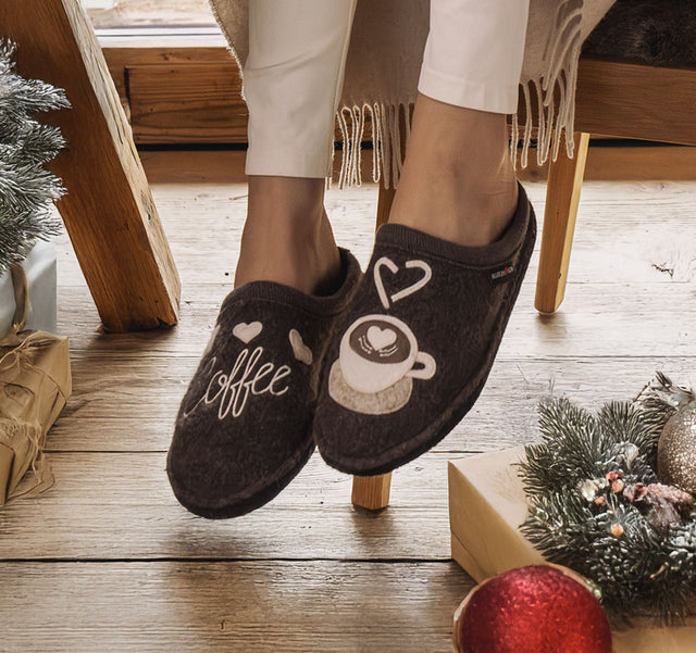 Primo piano di pantofole di lana coffee time con ambientazione natalizia