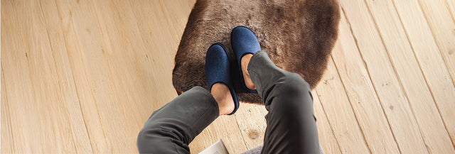 Ripresa dall'alto di uomo seduto indossando Soft Sabot Unisex jeans appoggiato su sedia con pelliccia mentre legge un libro