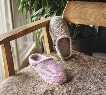 Piano di pantofole in lana de punto color rosa e color grigio